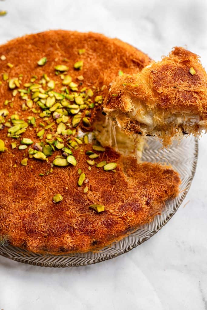 slice of kunafa being lifted out of a plate