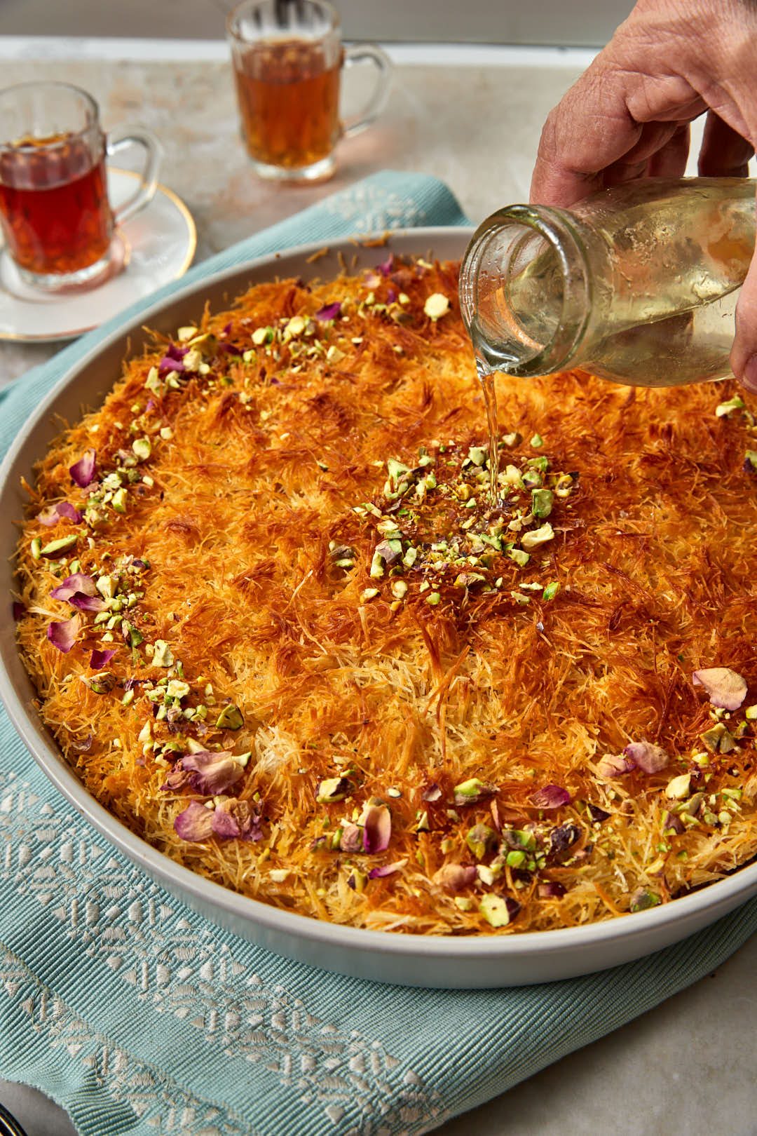sugar syrup being poured onto kunafa