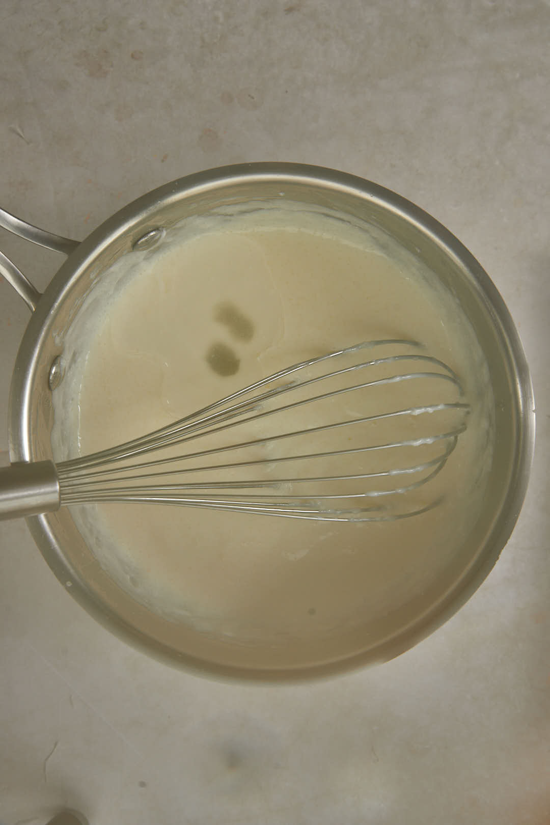 thickened cream filling in saucepan on white background.