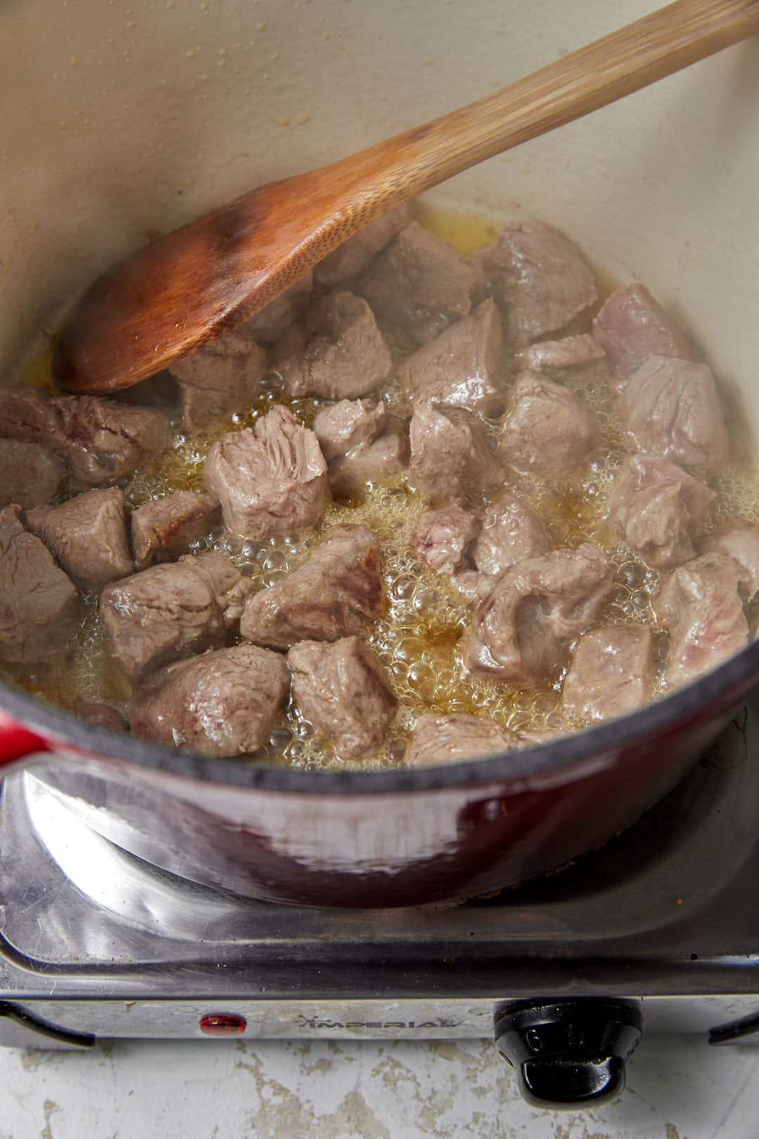 browned beef cubes in a hot deep pan.
