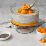 spoonful of juicy mangos being placed on chia pudding.
