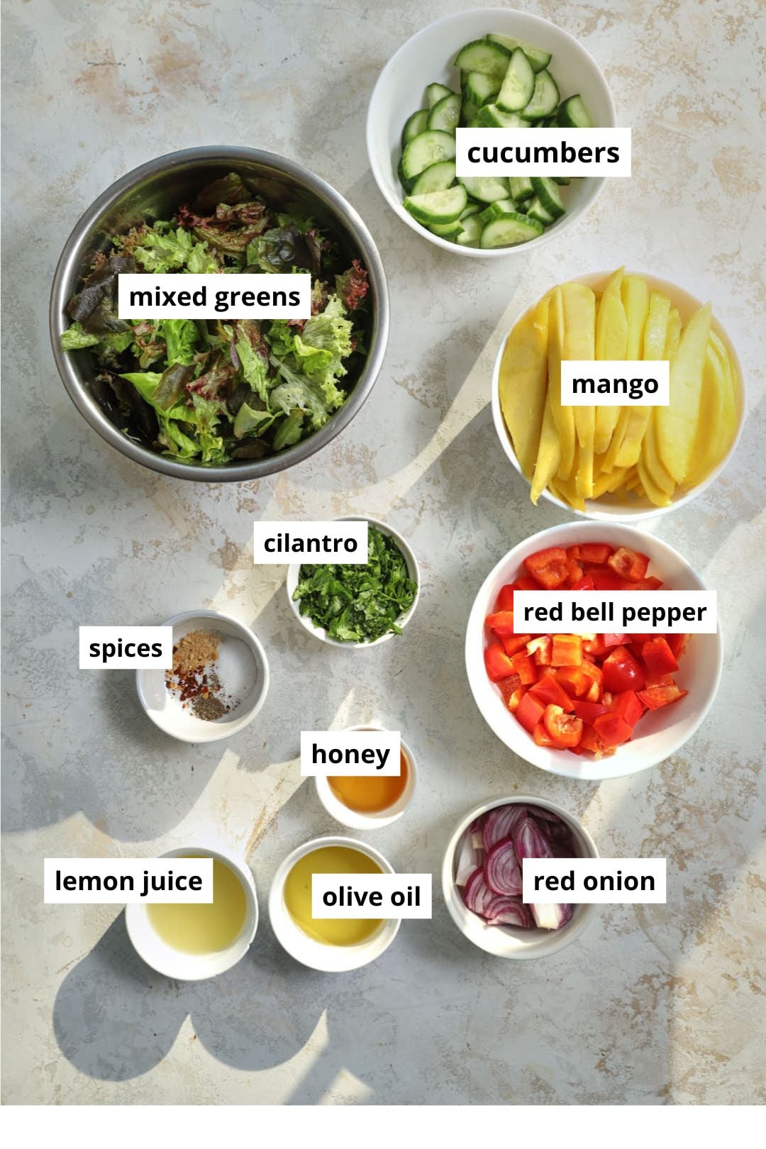 ingredients needed to make a summery mango salad on a white background.