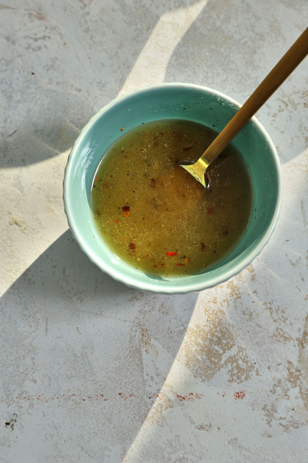 dressing ingredients for mango salad in a blue bowl a white background