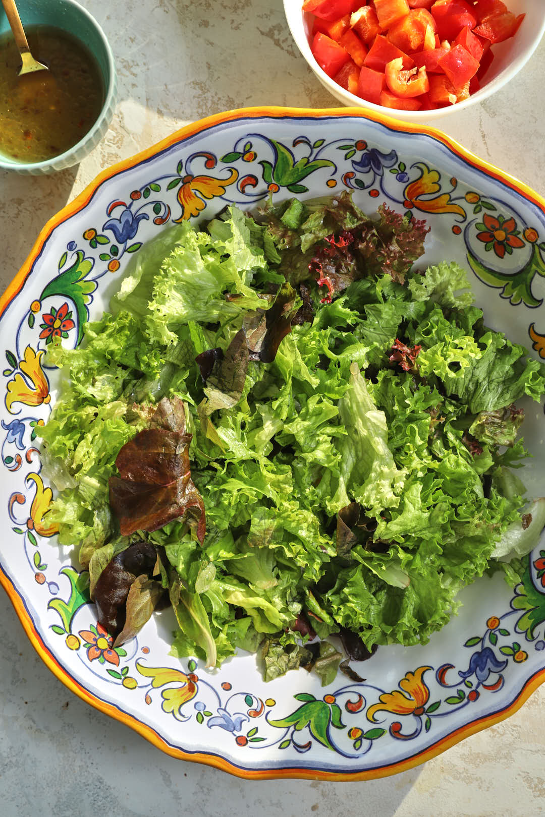 mixed lettuce in a large white floral platter.