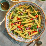 photo of a lettuce and mango salad in a large platter on a blue kitchen linen and on a white background.