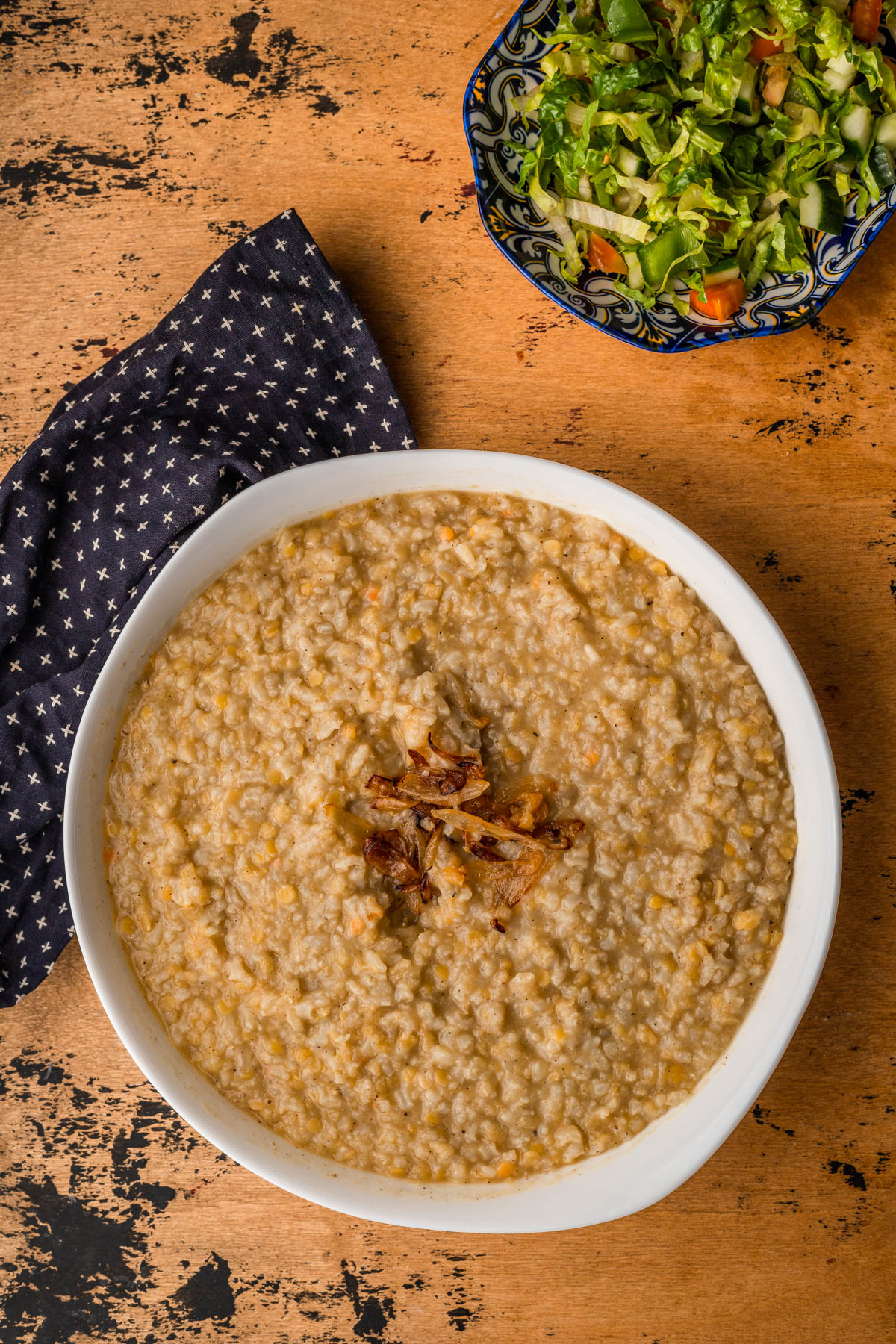 lebanese yellow lentils in a white bowl with a kitchen towel.