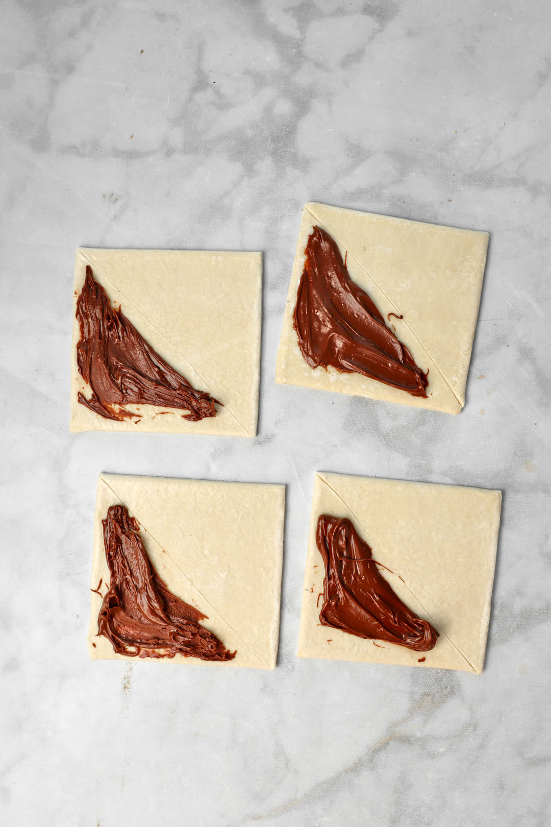 nutella spread on half of puff pastry squares