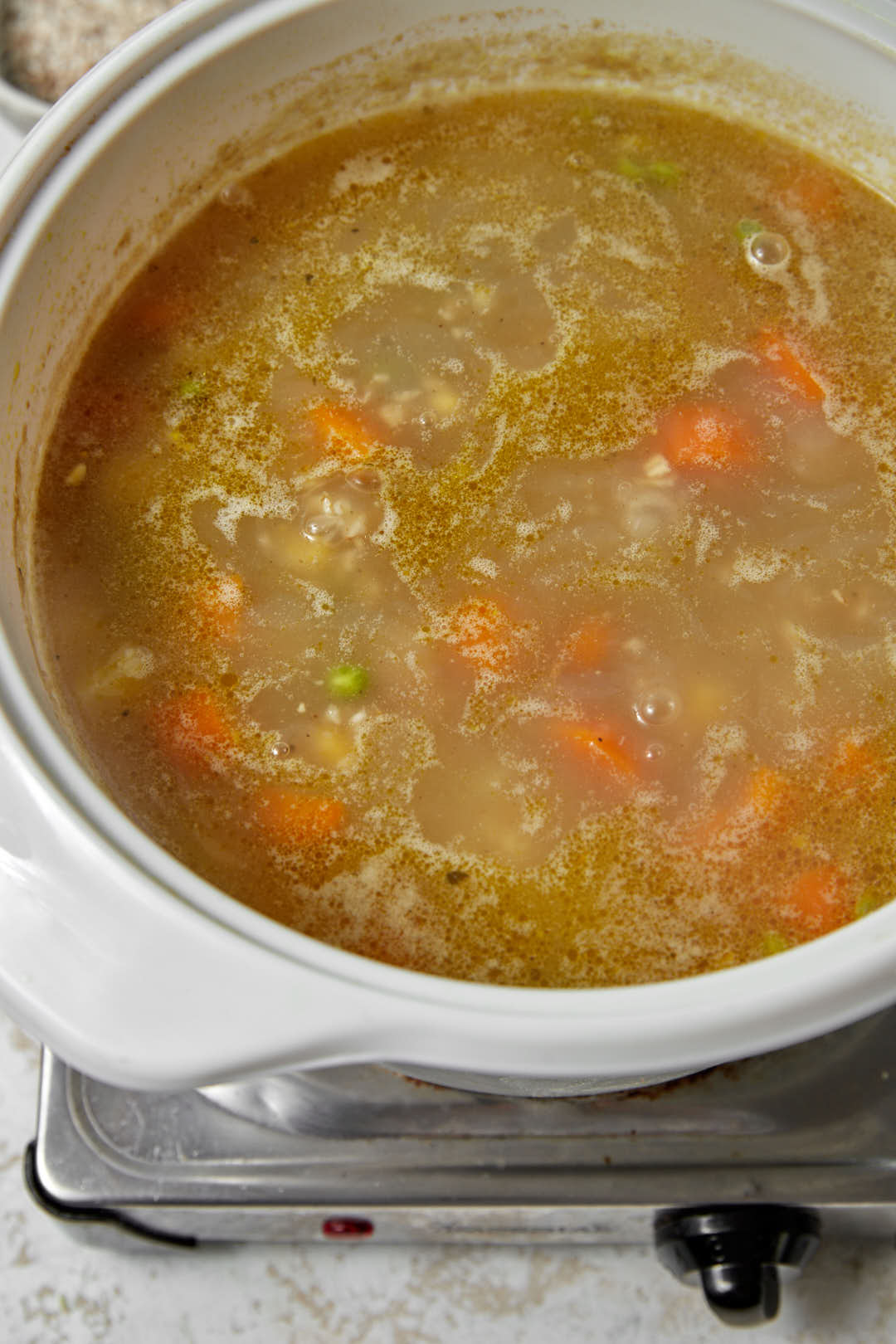 oatmeal soup being cooked in a large white pot.