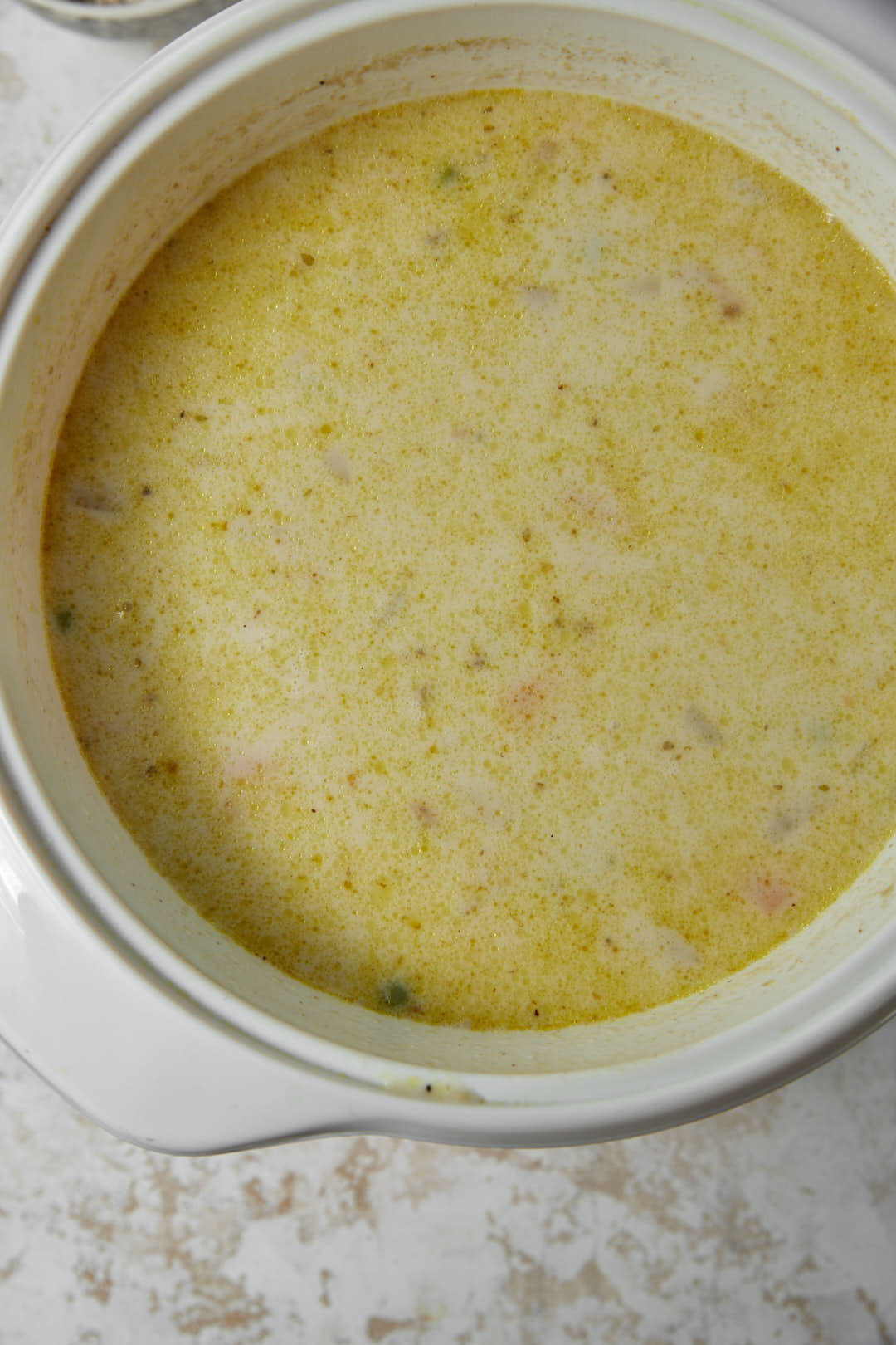creamy oatmeal soup in large white pot.