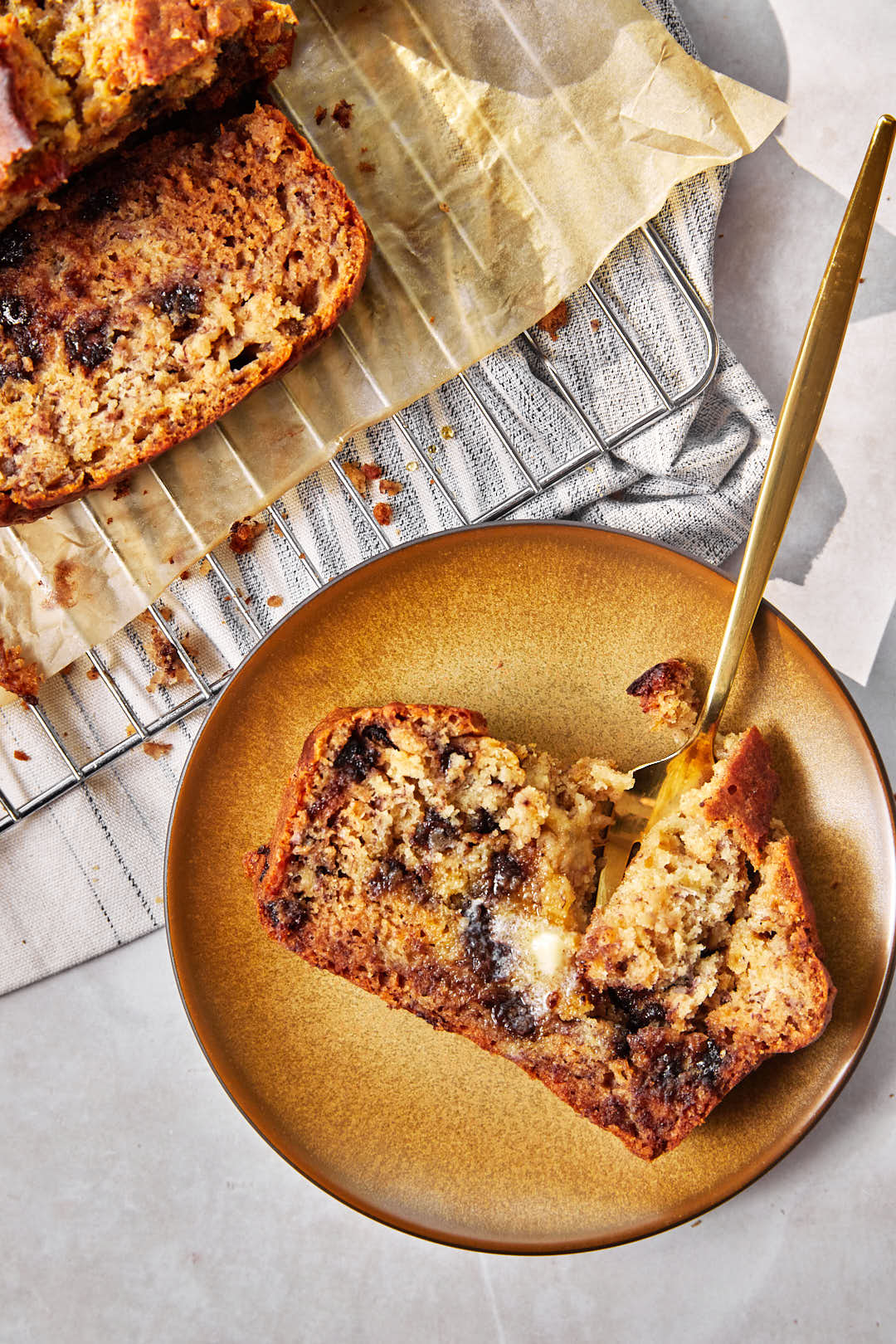 slice of olive oil banana bread on brown plate with a fork sticking out.