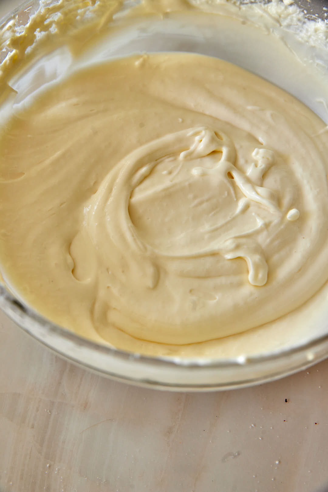 smooth cream cheese frosting in a glass bowl.
