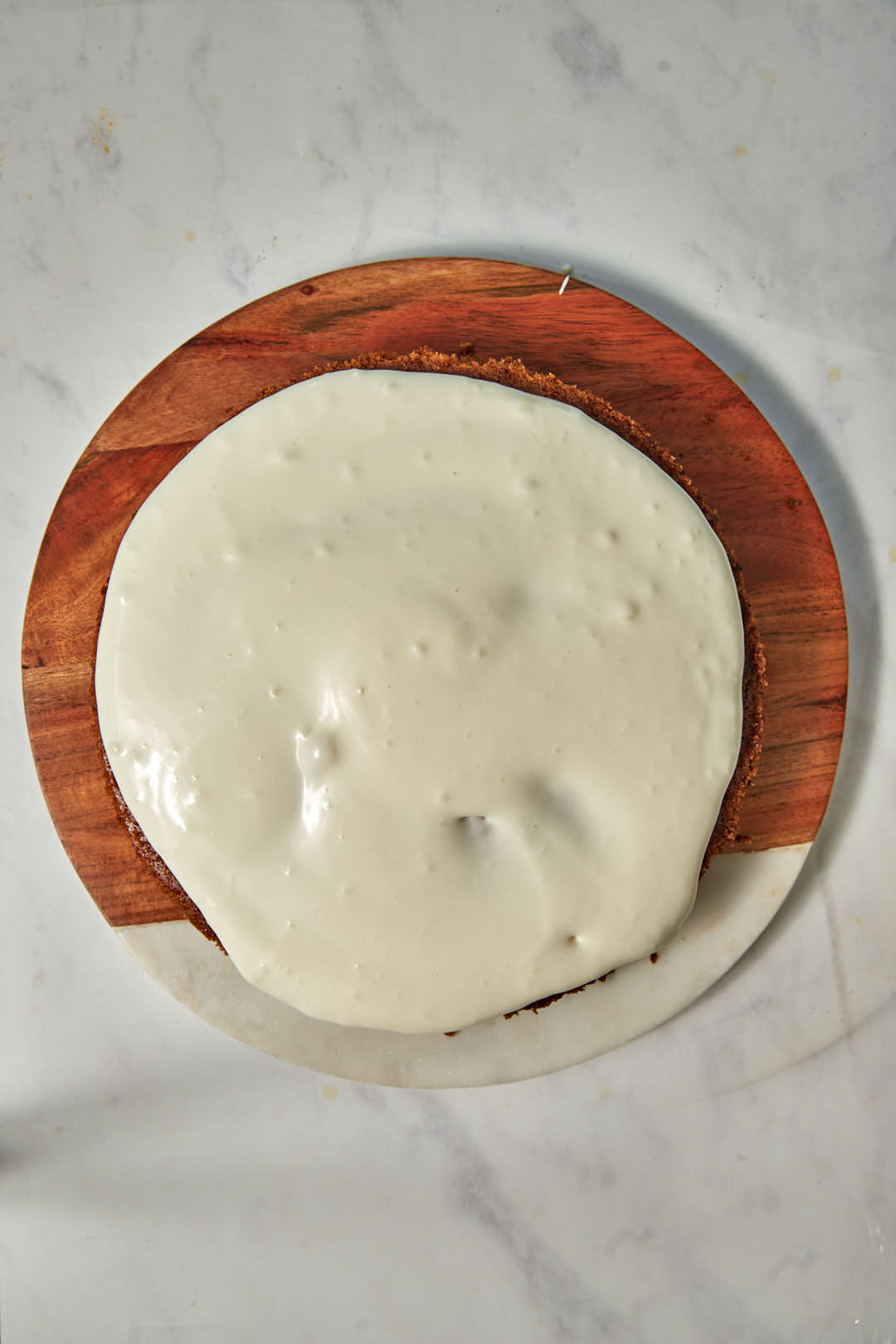 cream cheese frosting spread on one half of carrot cake.