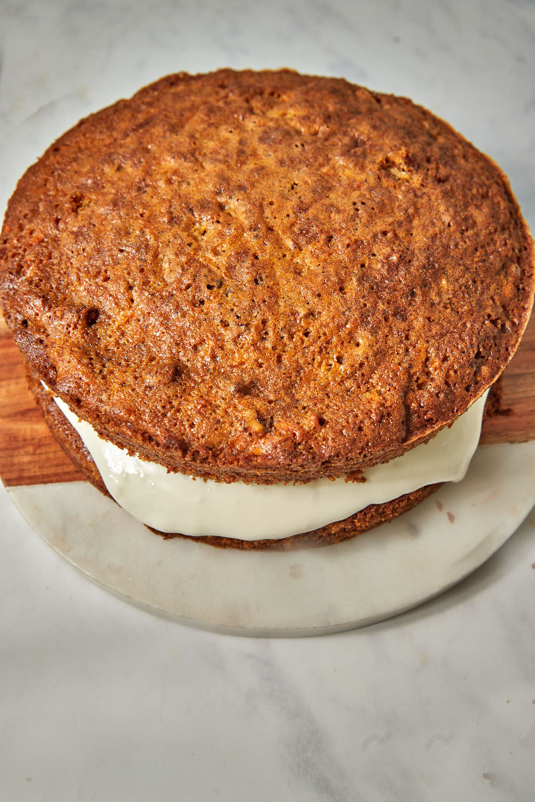 an unfrosted carrot cake on a wooden plate.