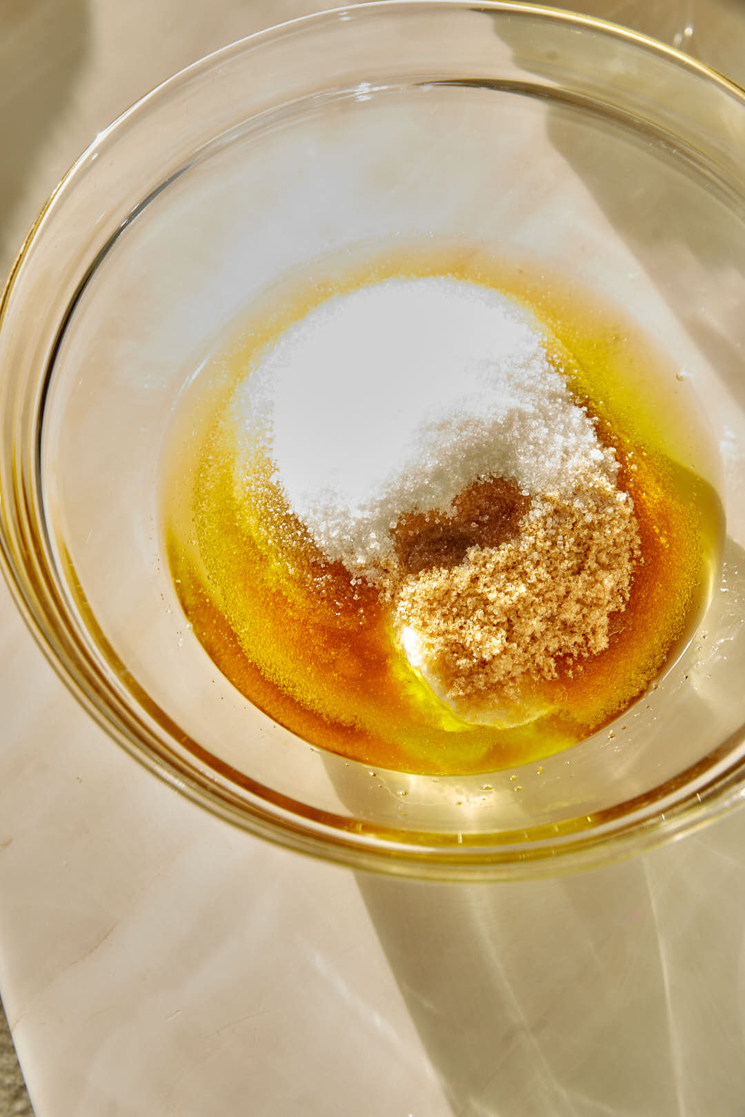 brown and white sugar in a bowl with olive oil.