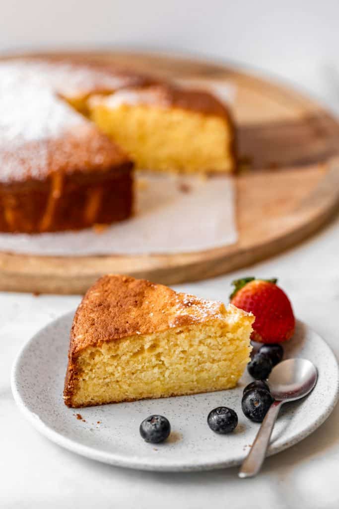 zoomed in photo of orange cake on a plate with berries