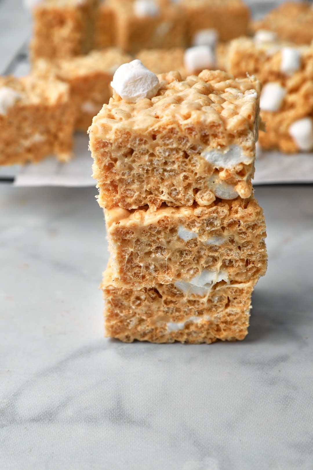 stack of three peanut butter rice krispie treats with gooey marshmallow pockets.