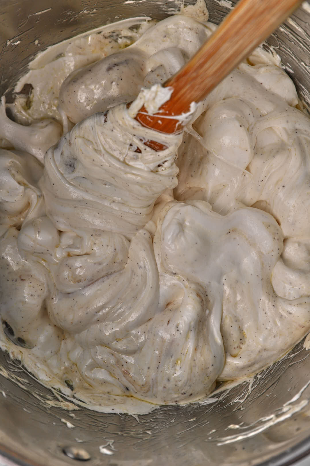 melted marshmallows being stirred with a spatula in a large pot.