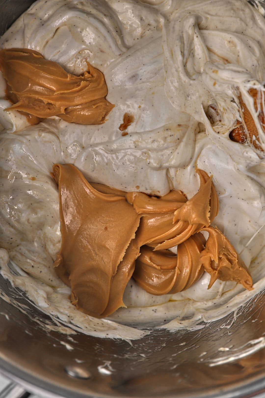 creamy peanut butter added on top of melted marshmallows in a pot.