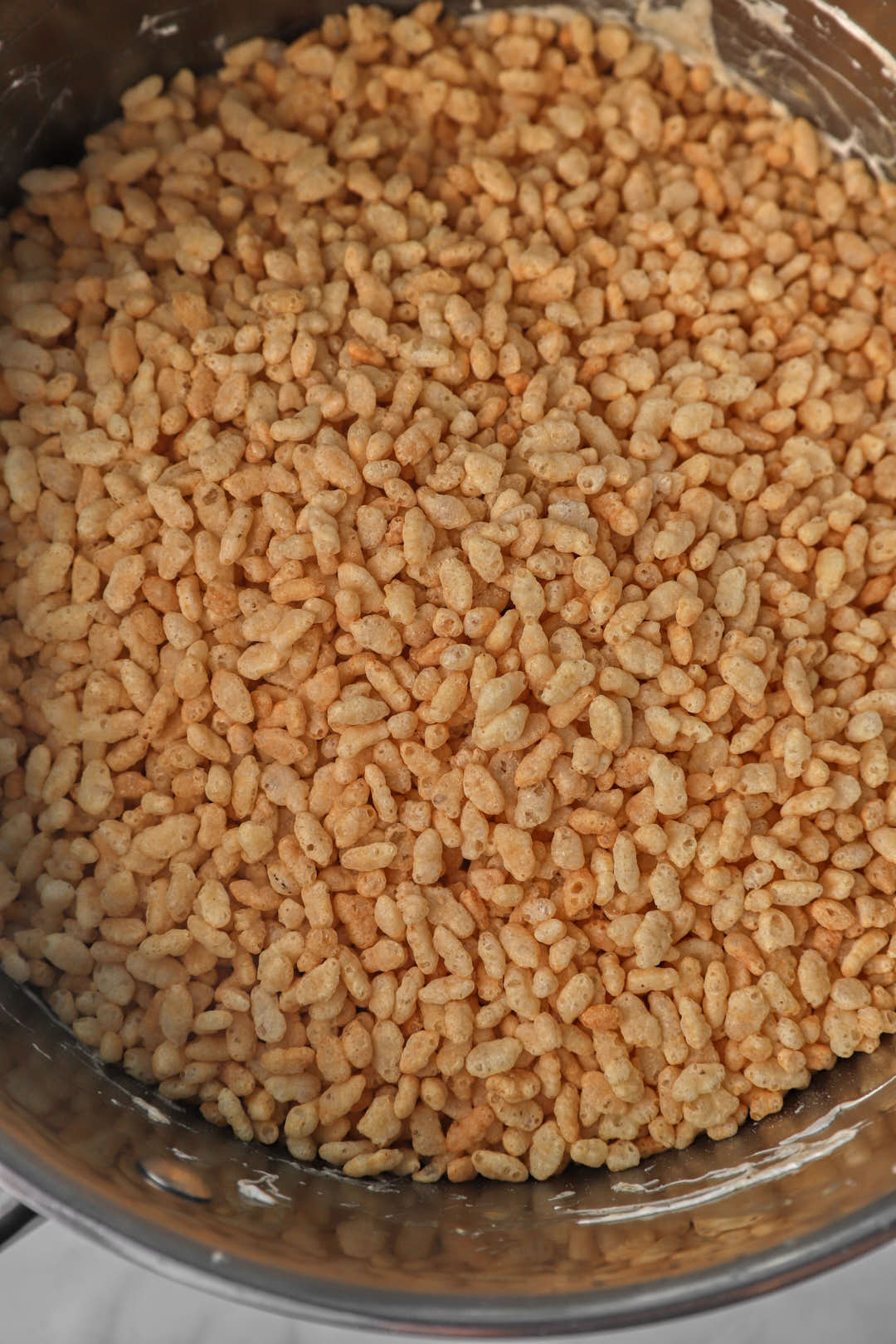 Rice Krispies cereal added on top of the peanut butter marshmallow mixture in a pot.