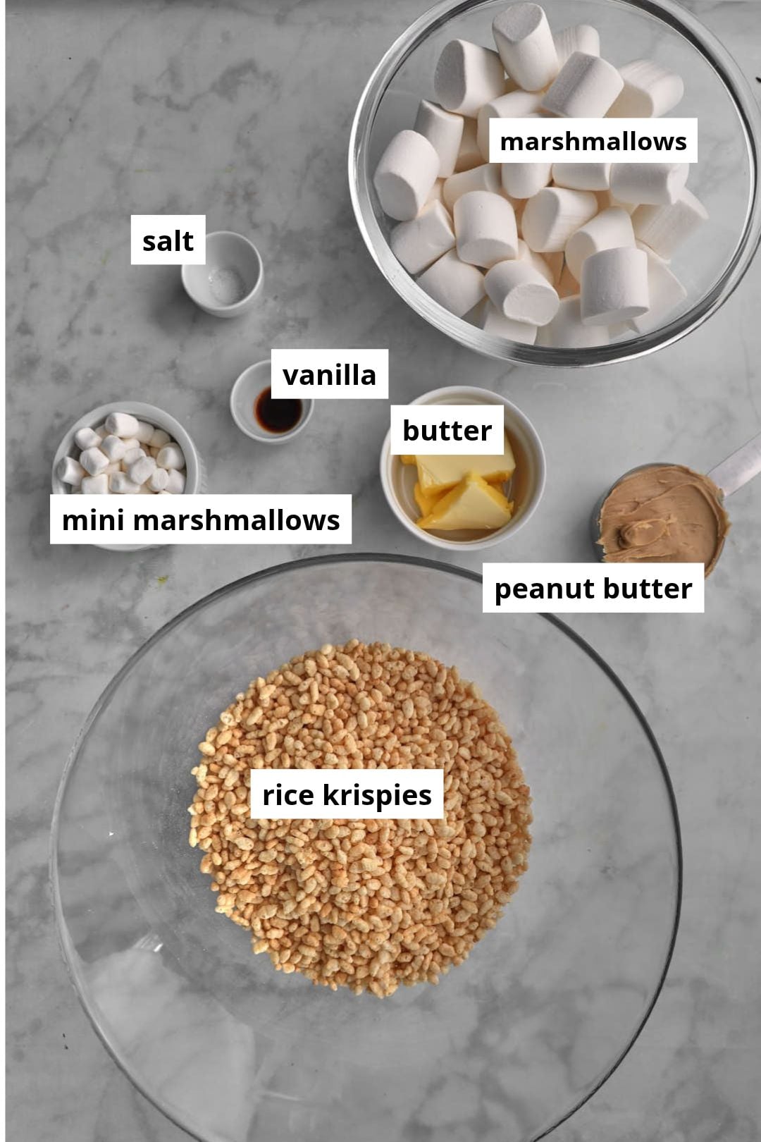 ingredients needed for peanut butter rice krispy treats on a marble background.