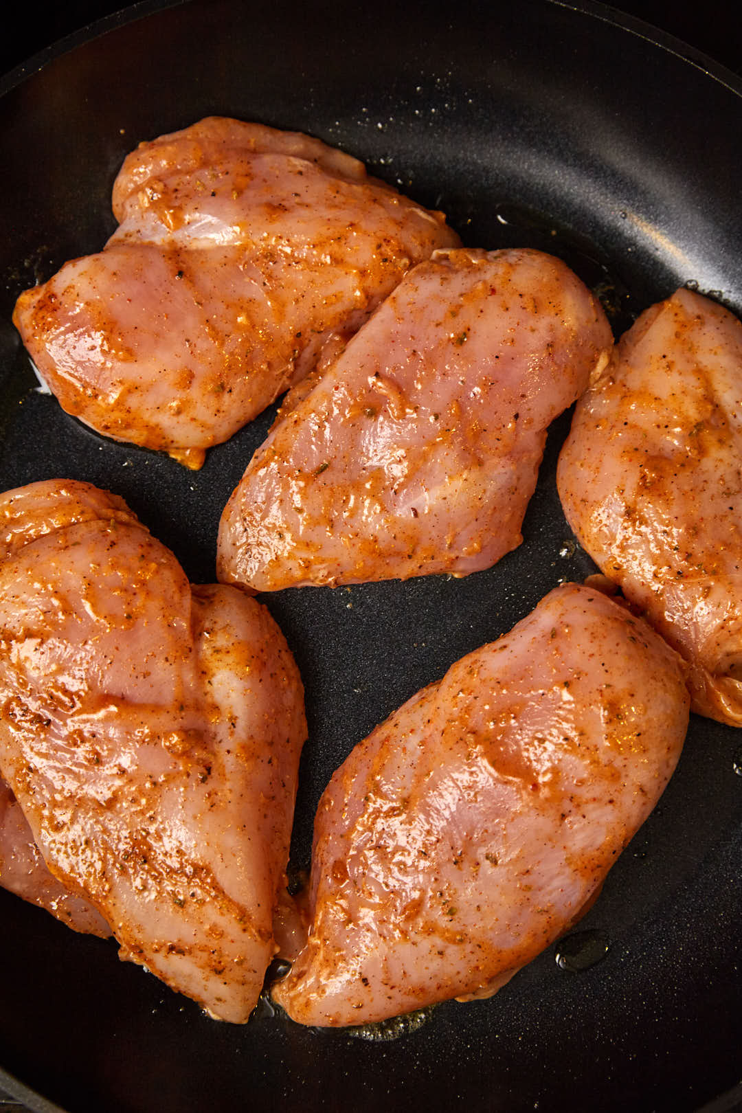 peri peri marinated chicken breasts in a large skillet.
