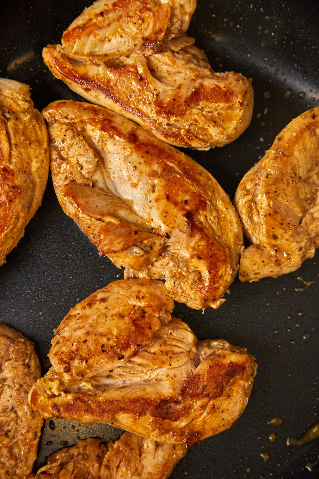 Chicken breasts after being cooked in a skillet.