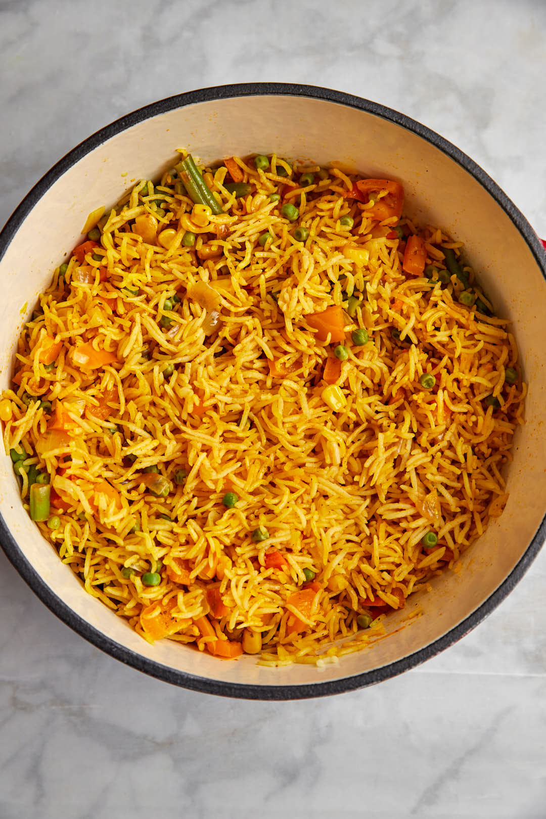 cooked peri peri rice in a large pot on a white background.