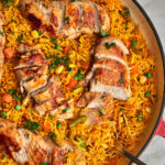 skillet with peri peri rice and sliced chicken breasts.