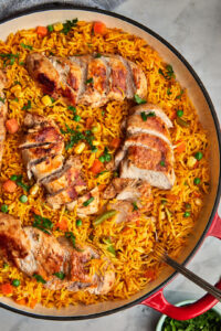 skillet with peri peri rice and sliced chicken breasts.
