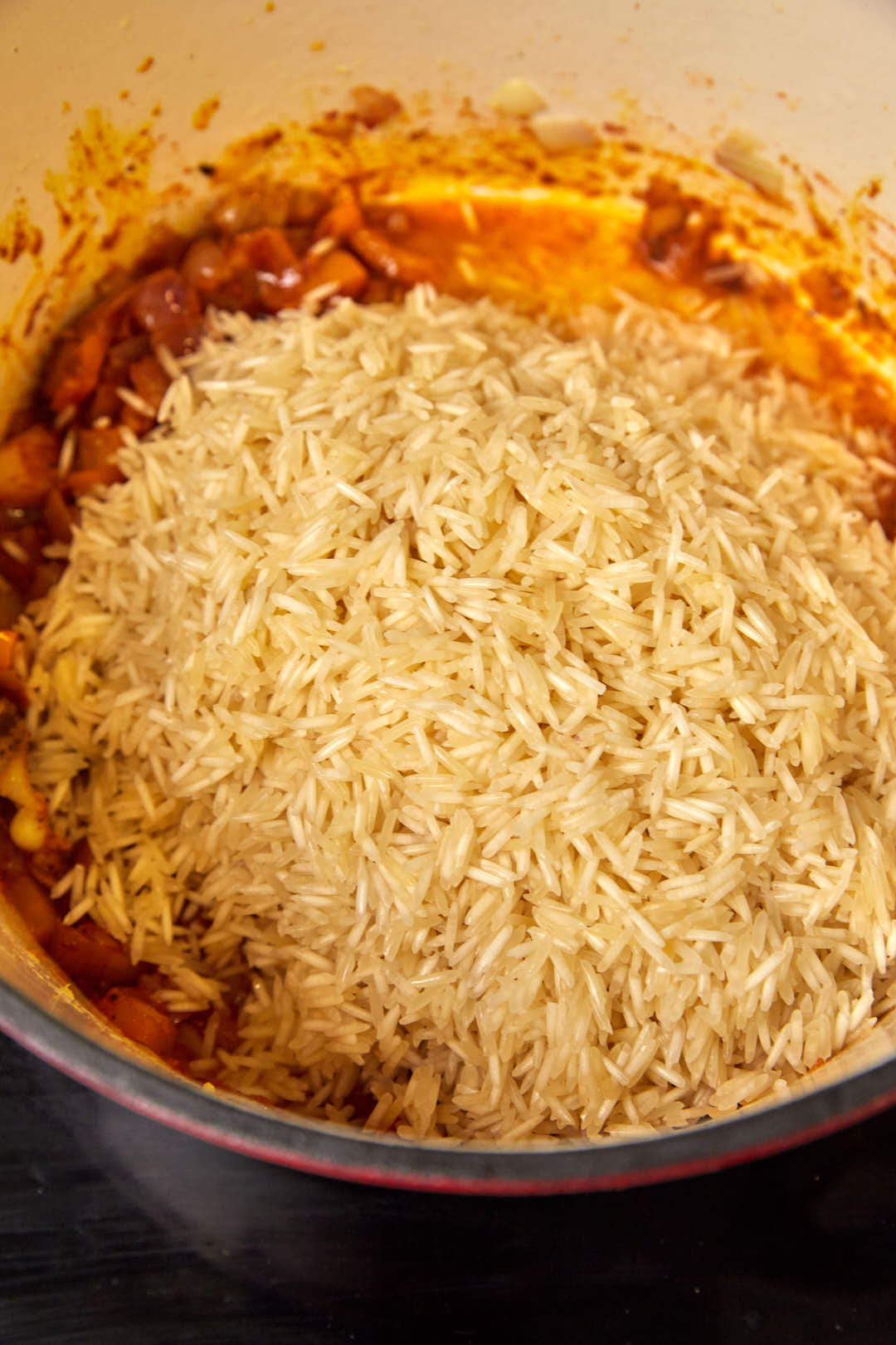 Basmati rice in a large skillet with tomato paste.