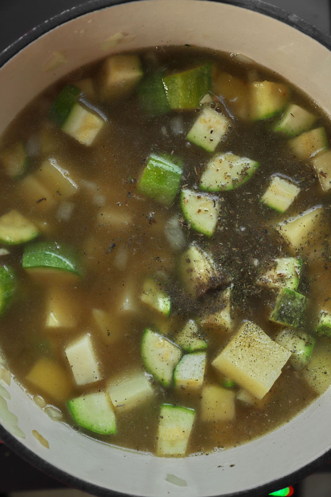 broth added to zucchini and potato cubes in a large pot.