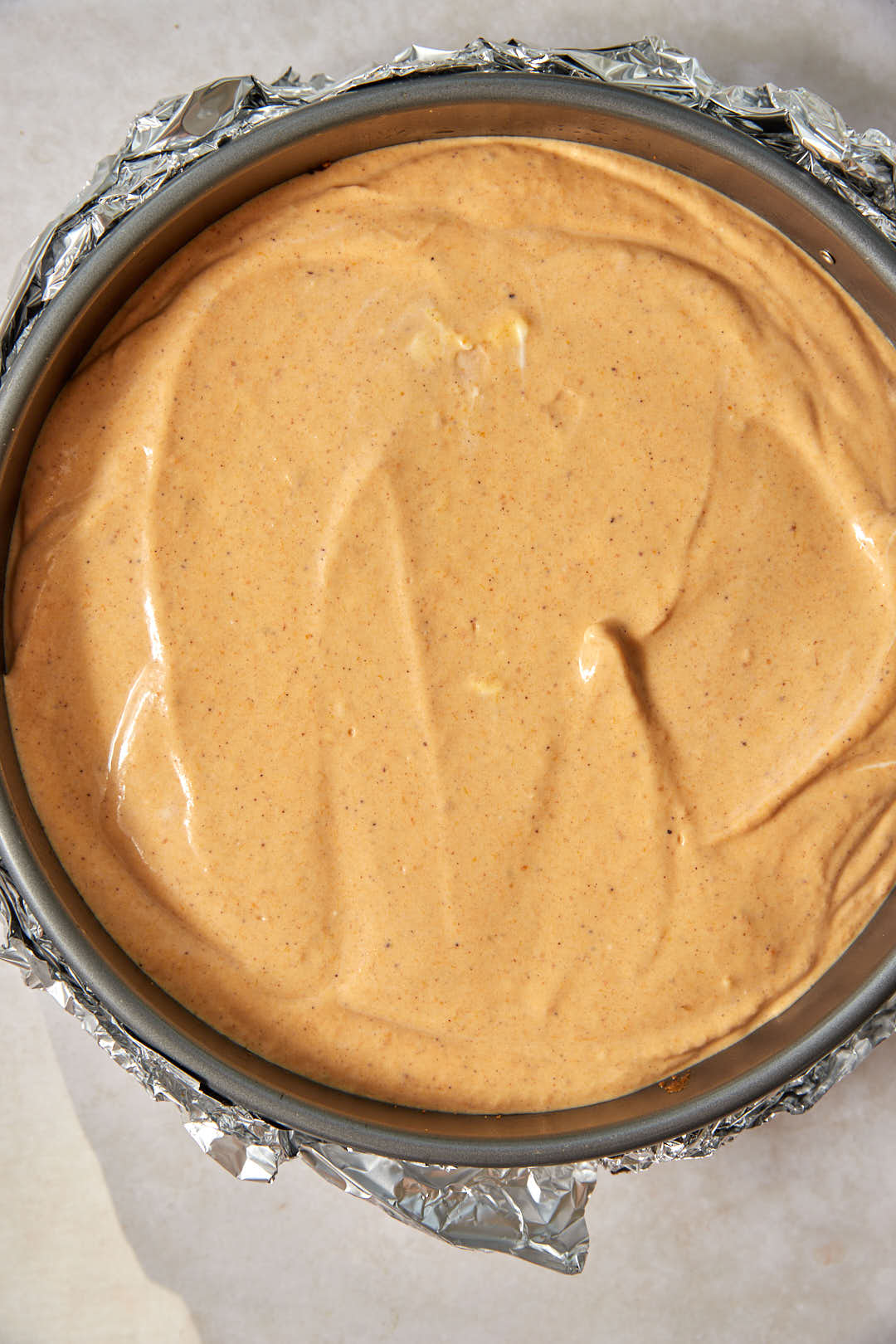 Pumpkin cheescake batter added to biscoff crust in springform pan.