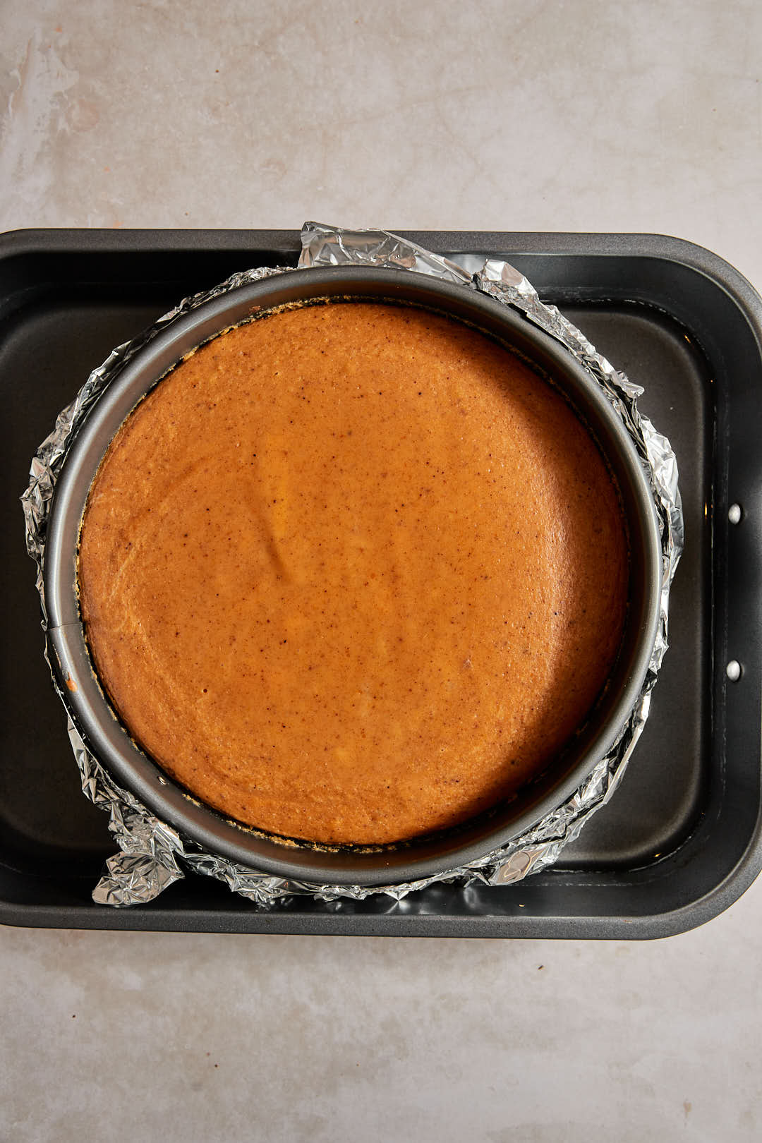 pumpkin cheesecake in water bath after baking.