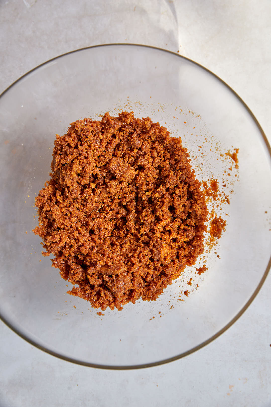 biscoff it crumbs mixed with butter in glass bowl.biscu