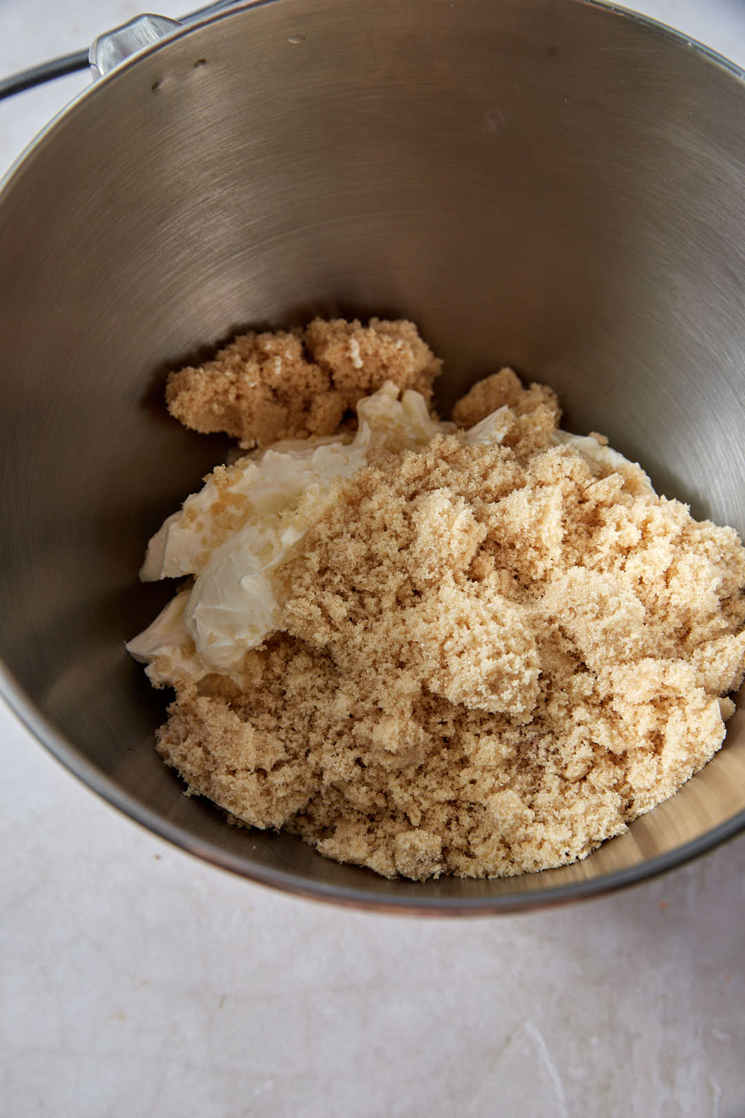 Brown sugar and white sugar and cream cheese in mixing bowl.