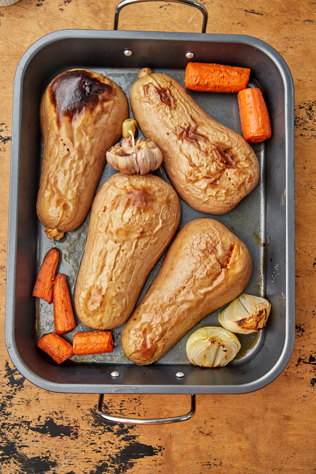 butternut squash flesh side down on roasting pan after being roasted.