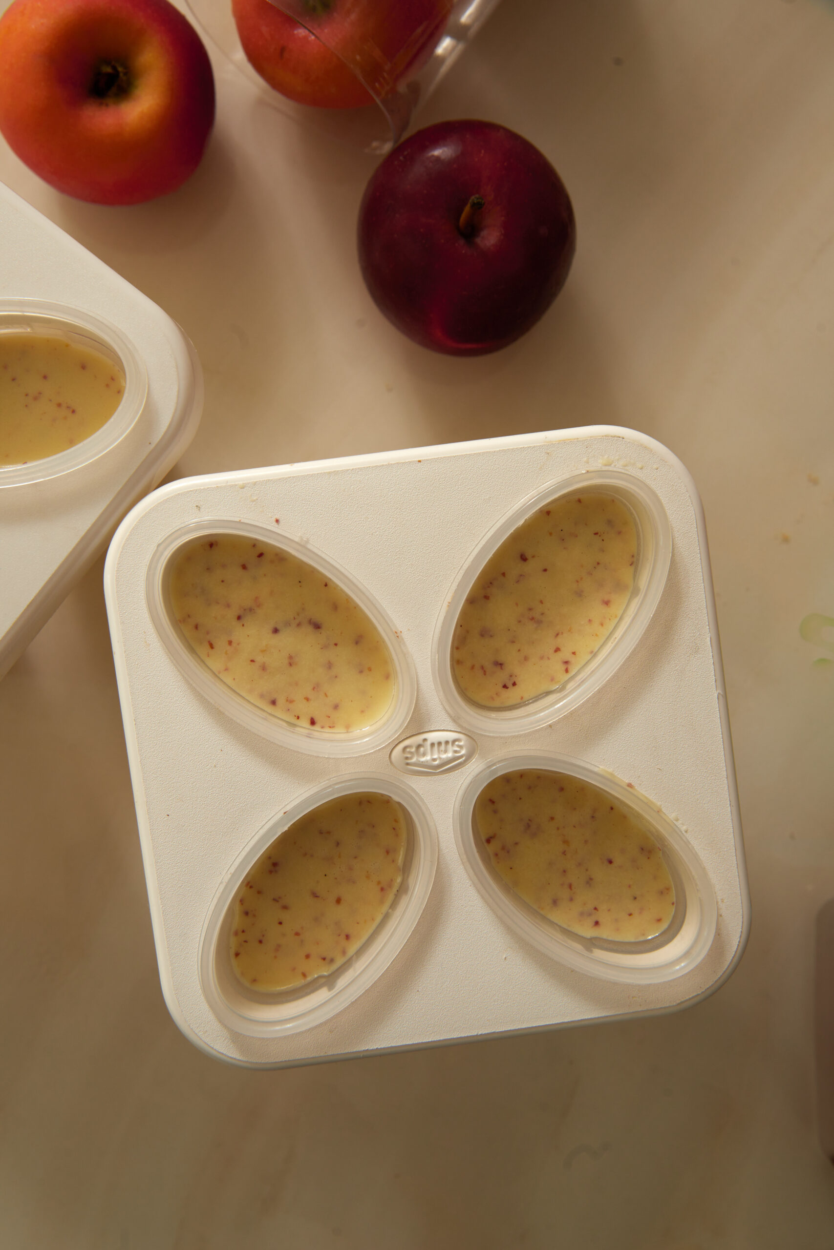 Apple popsicles being poured into molds.
