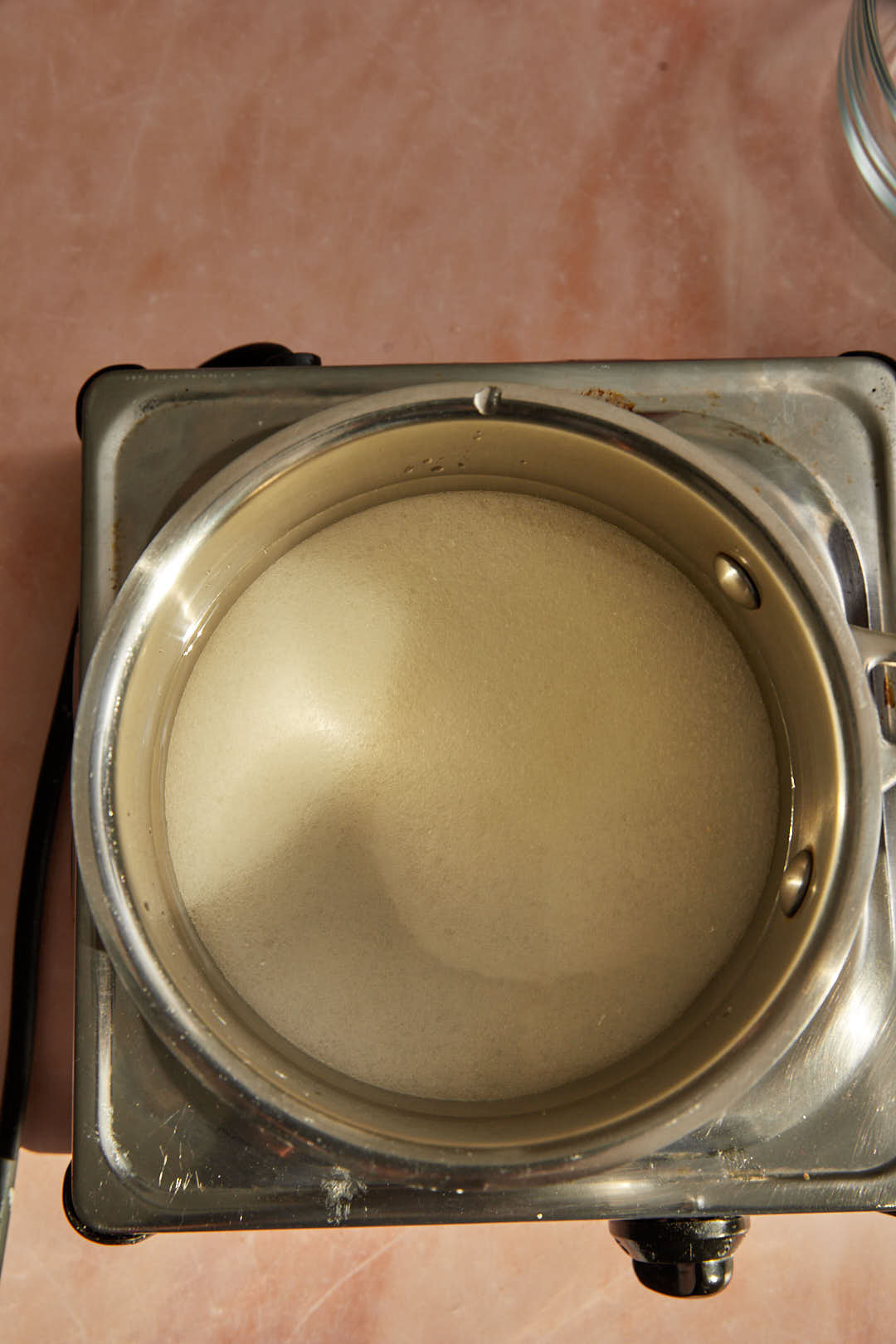 Sugar and water in a medium saucepan over a hot plate.