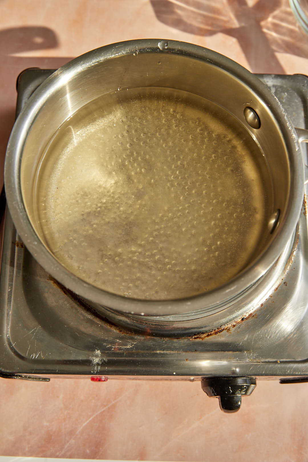 simmering sugar water to make sugar syrup in a saucepan.
