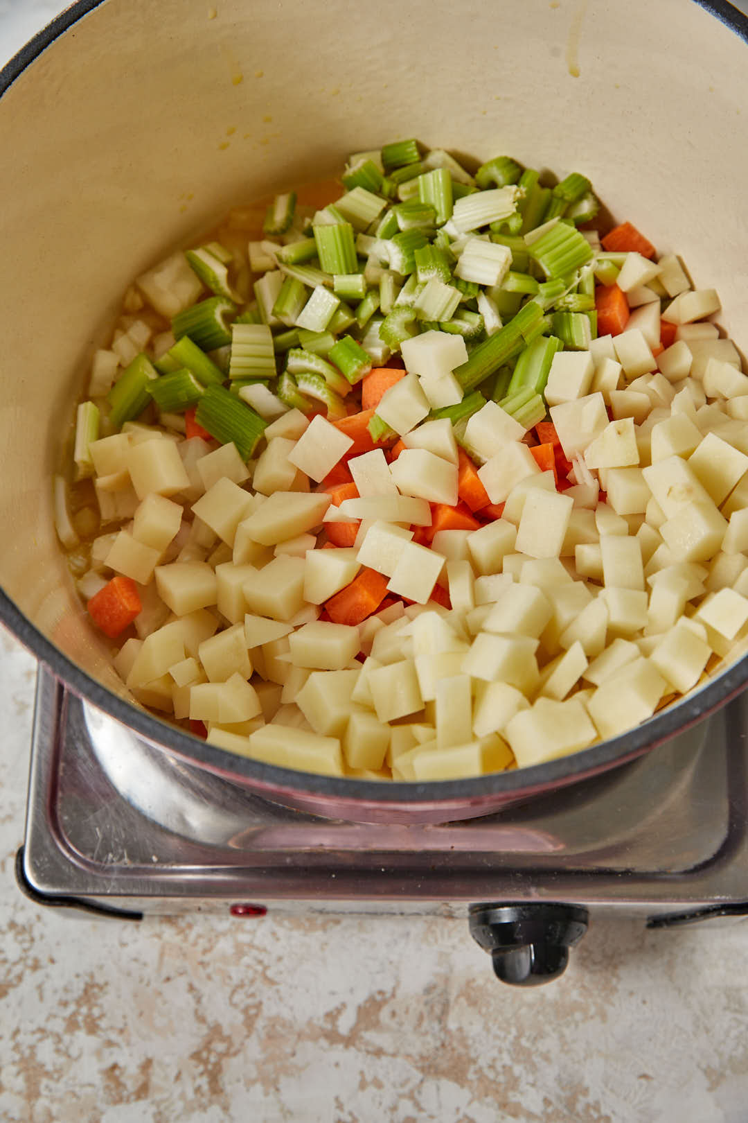 diced onion, celery, carrots and potato added to a pot with olive oil and butter.