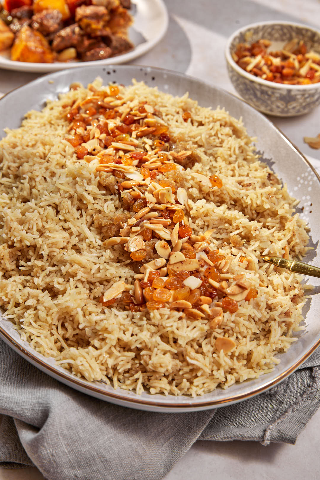 a large platter of raisin rice (ruz bilkhalta) with a golden serving spoon.