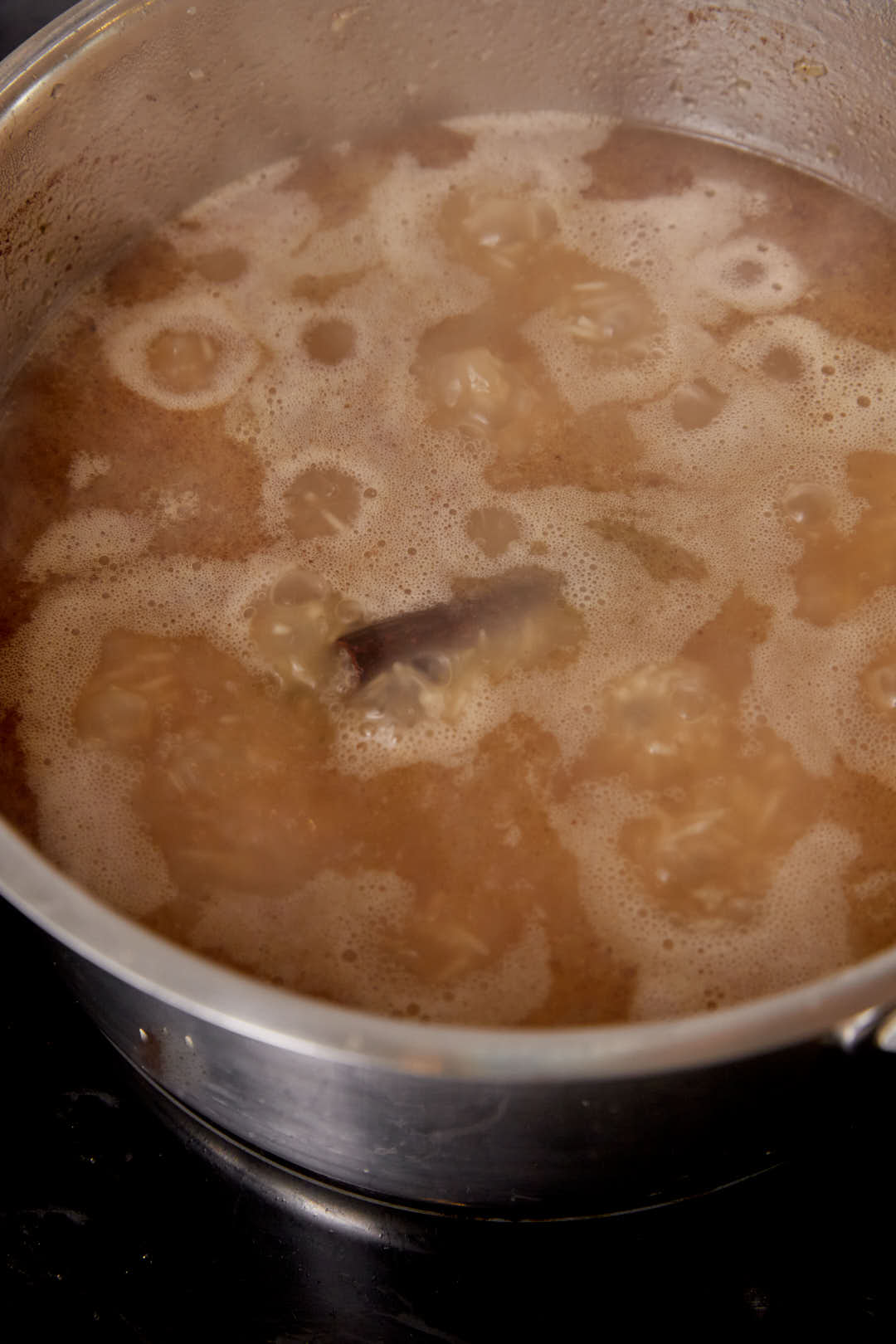 A large pot of broth simmering to cook rice.