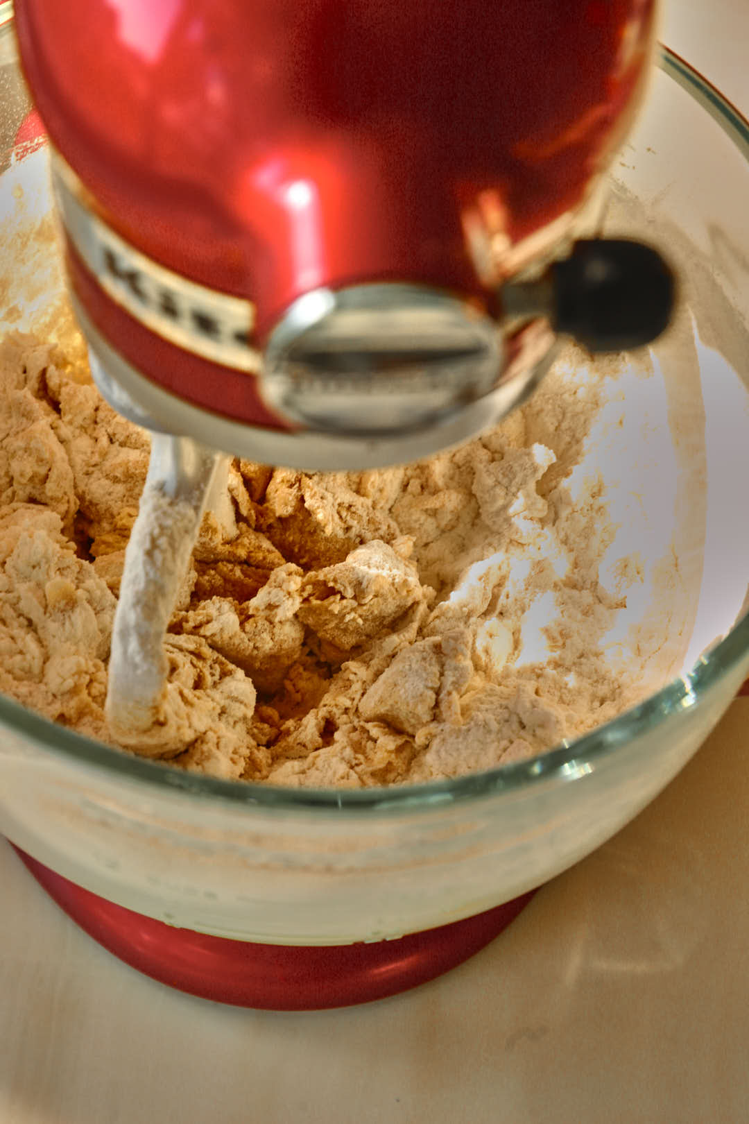 dry ingredients added to cookie dough in a glass bowl of stand mixer.