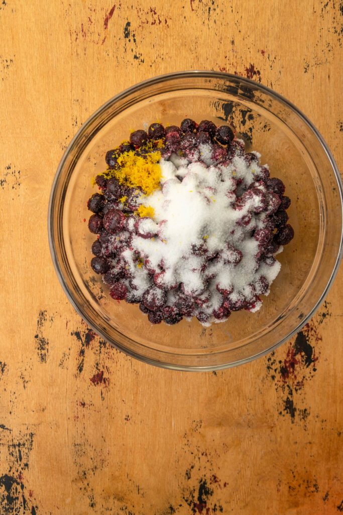 bowl of blueberries with sugar and lemon zest.