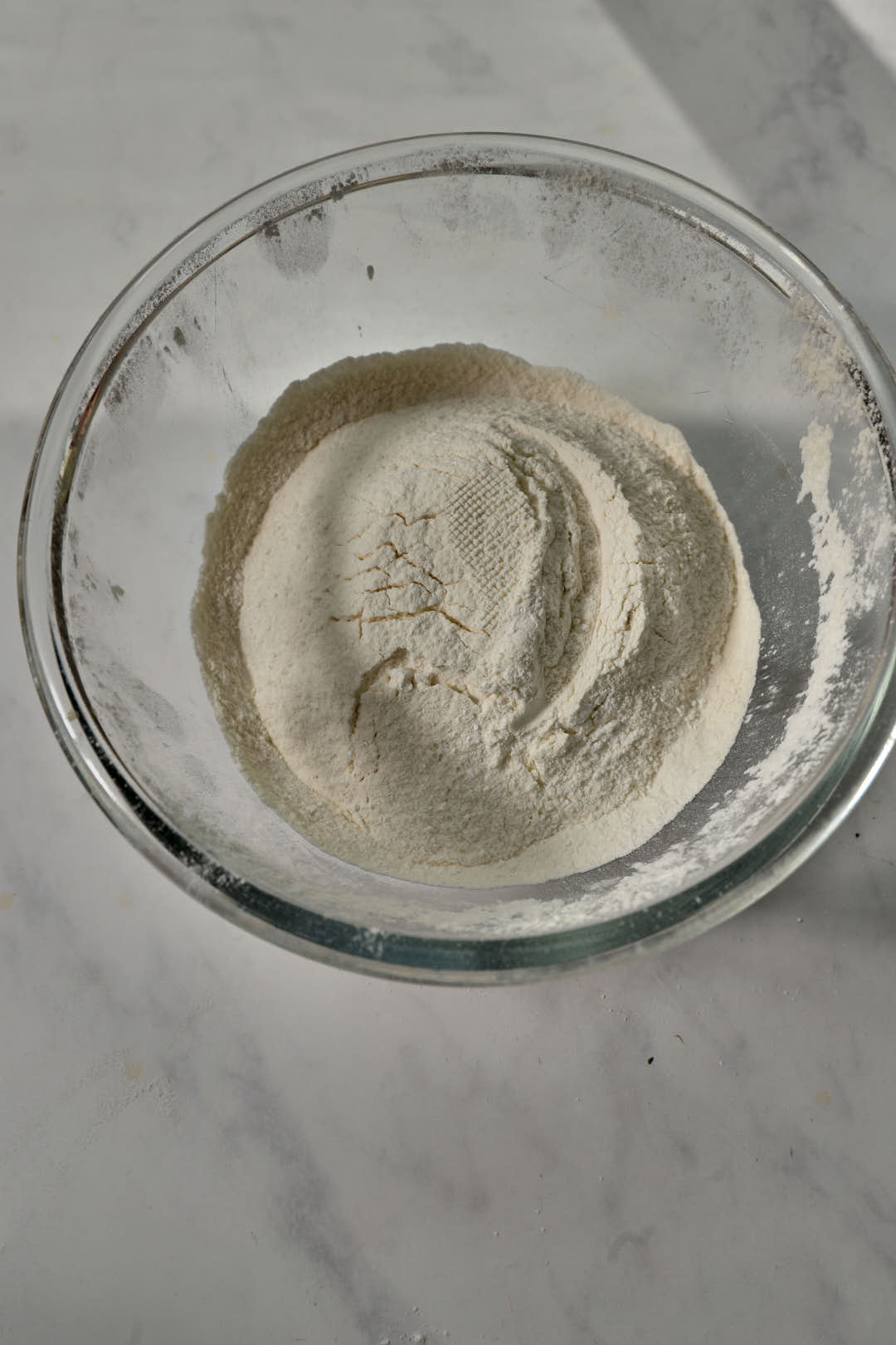 flour and dry ingredients for cookies in a glass bowl.