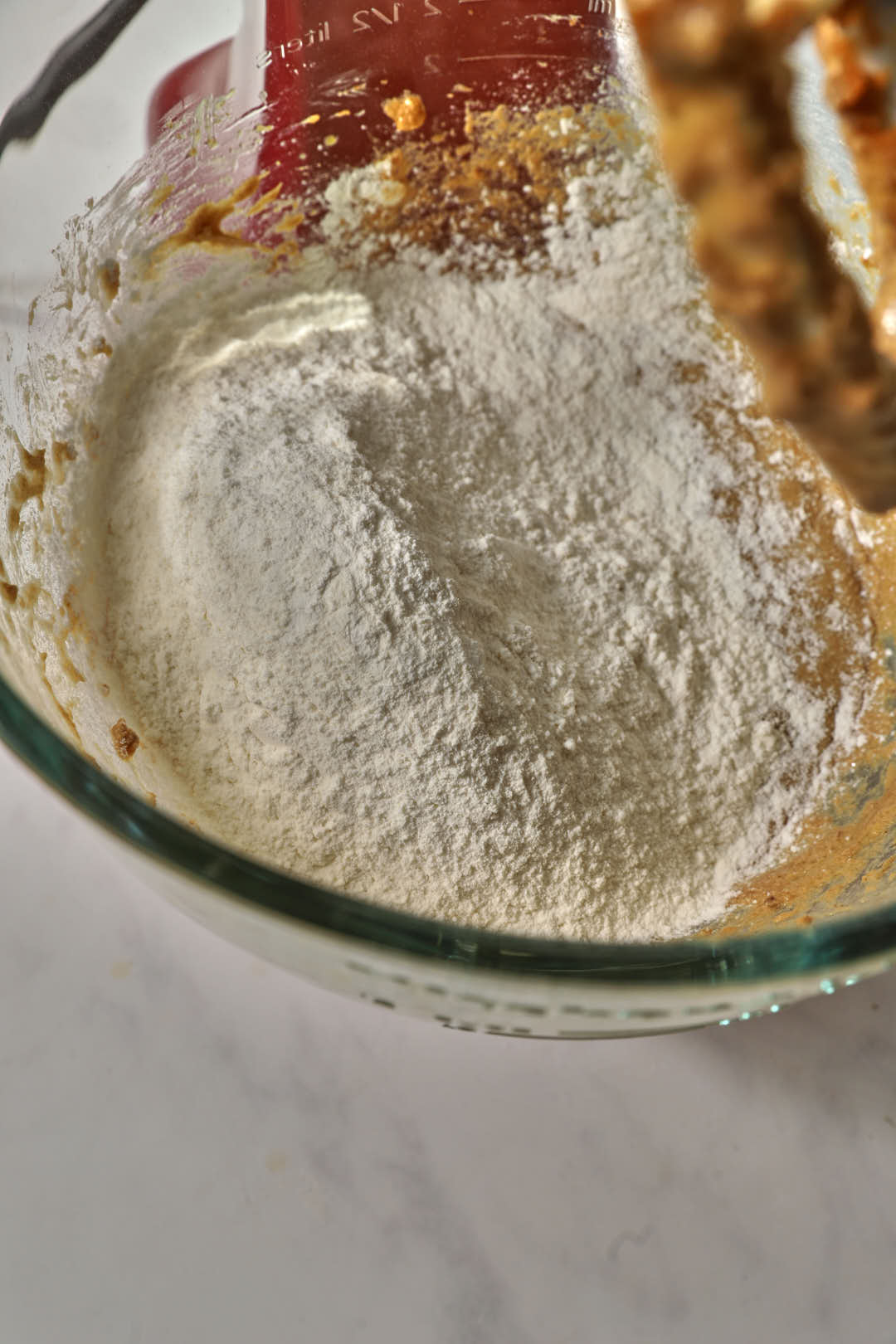 dry ingredients added to butter/sugar mixture in a glass bowl.