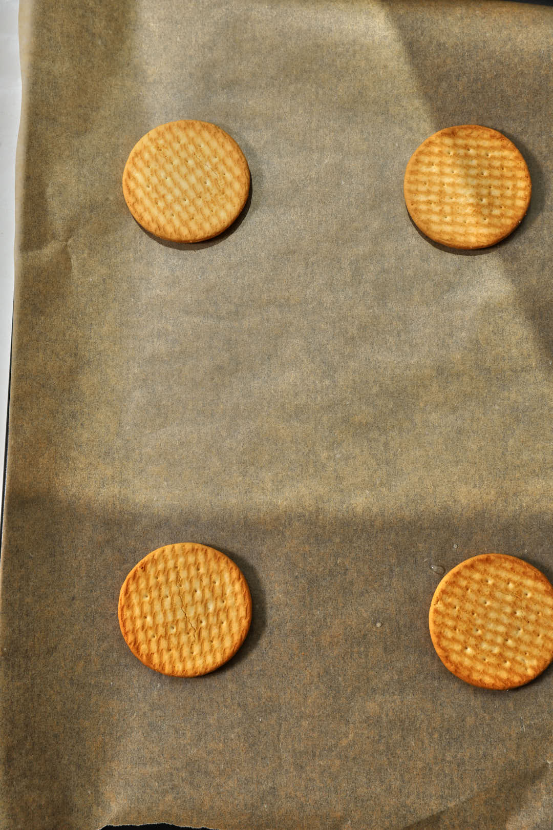biscuits added to a parchment paper lined baking sheet.