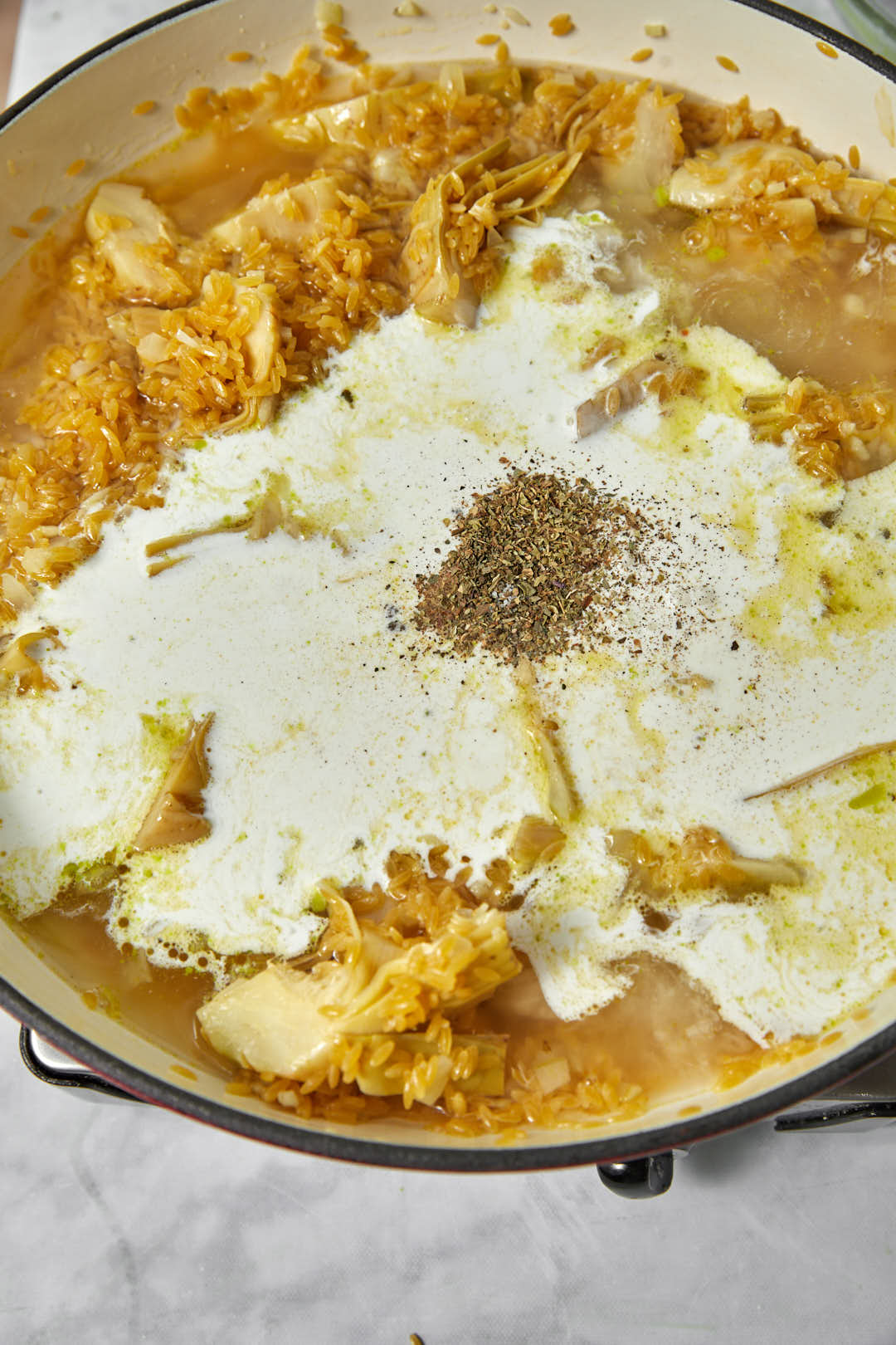 heavy cream and herbs added to orzo in a large skillet.