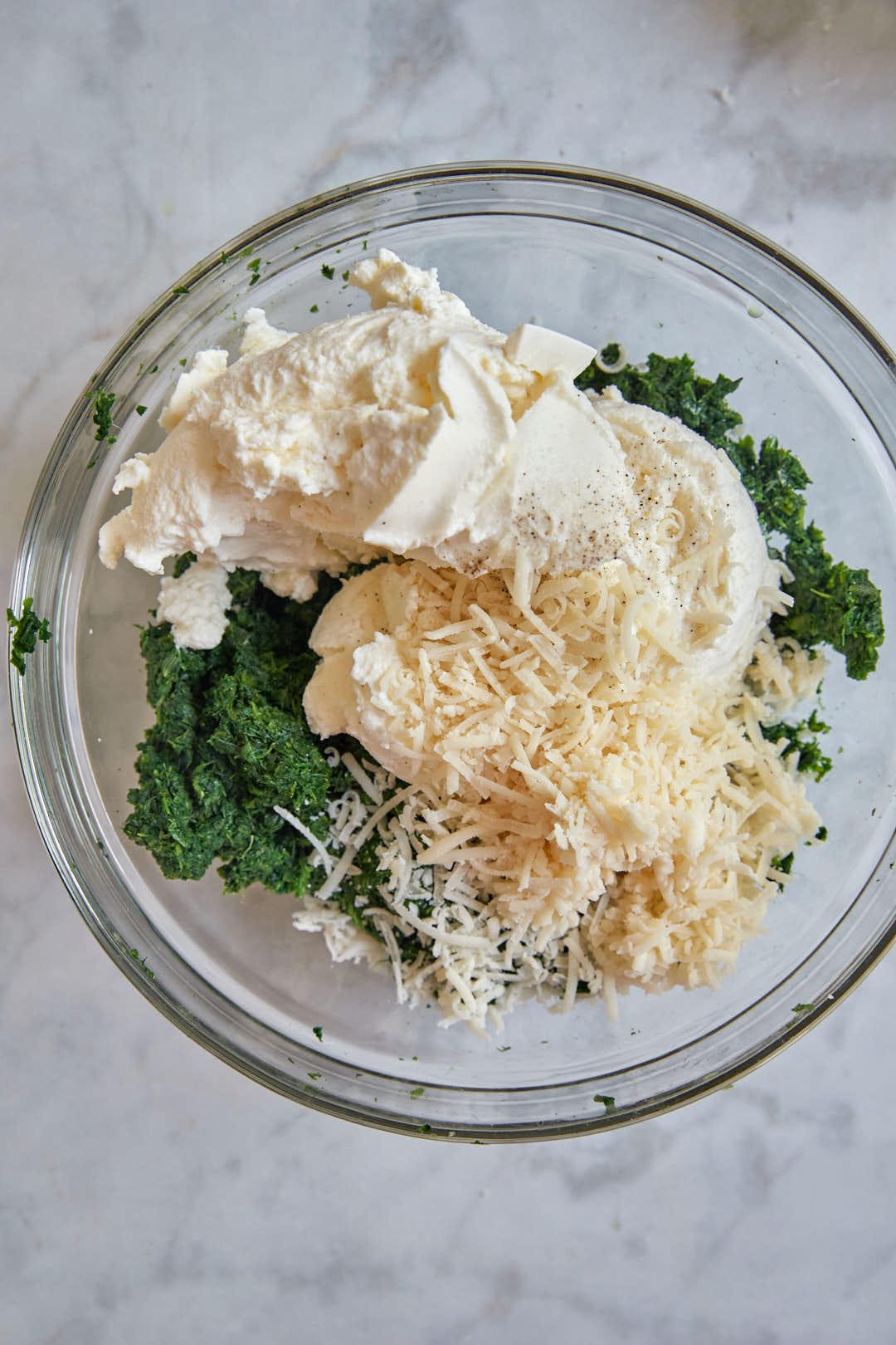 spinach ricotta filling ingredients in a glass bowl. 