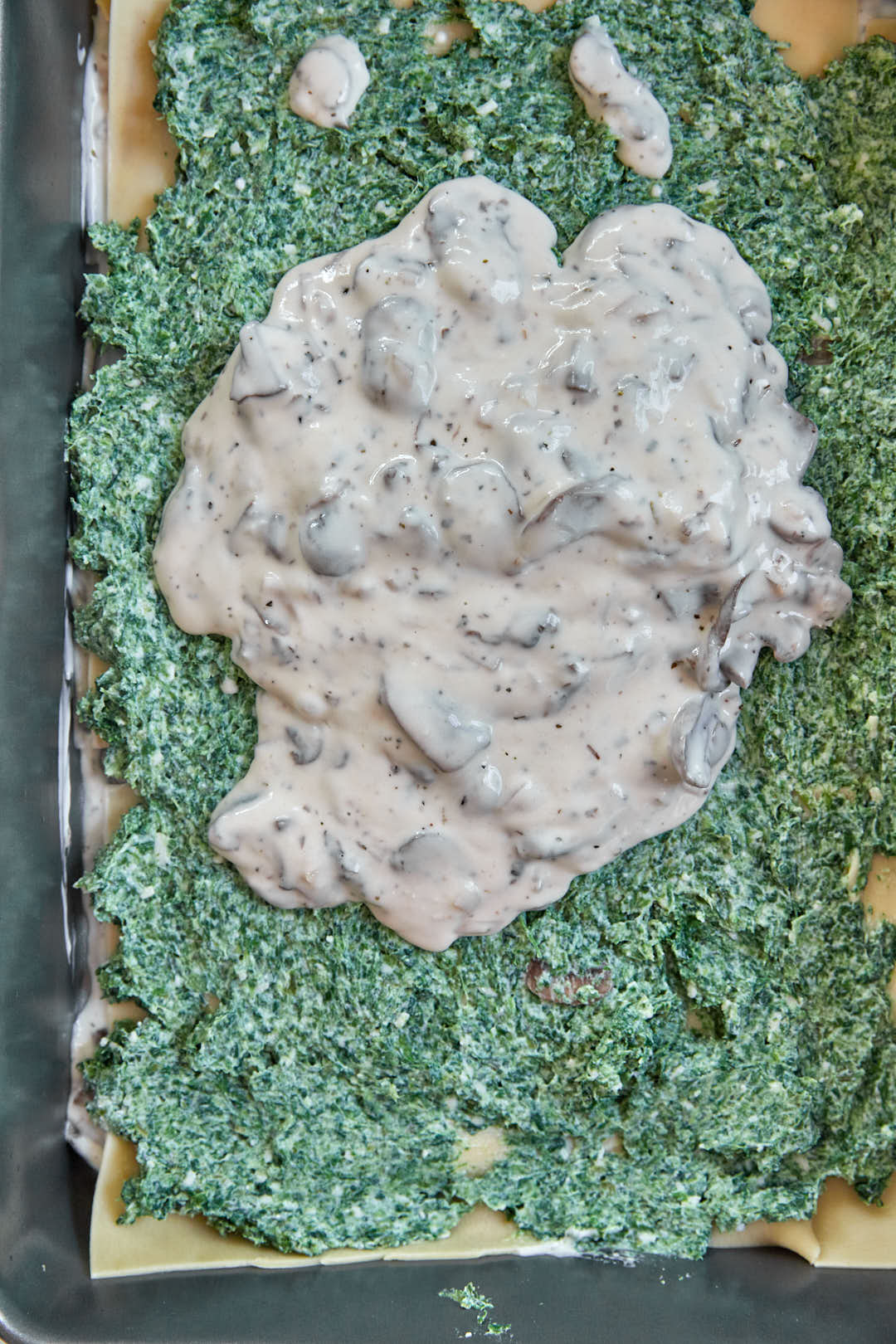 mushroom sauce being added to spinach ricotta filling.